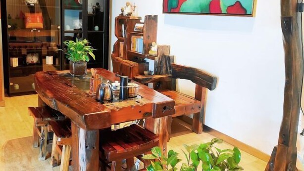A rustic wooden dining table with chairs, surrounded by shelves with various items. - Jinjiang Inn (Baotou Railway Station) (Baotou)
