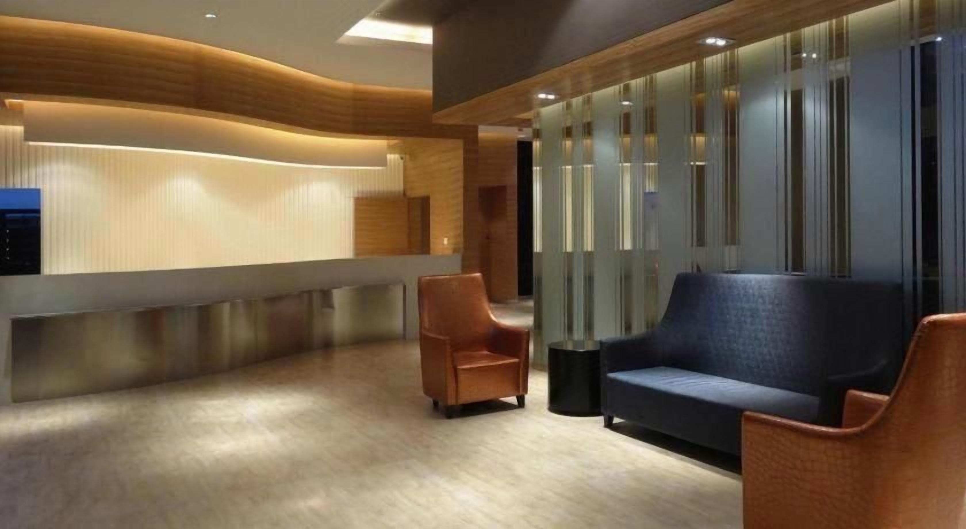 A reception area with a counter, seating, and a wall with vertical lines.