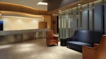 A reception area with a counter, seating, and a wall with vertical lines.