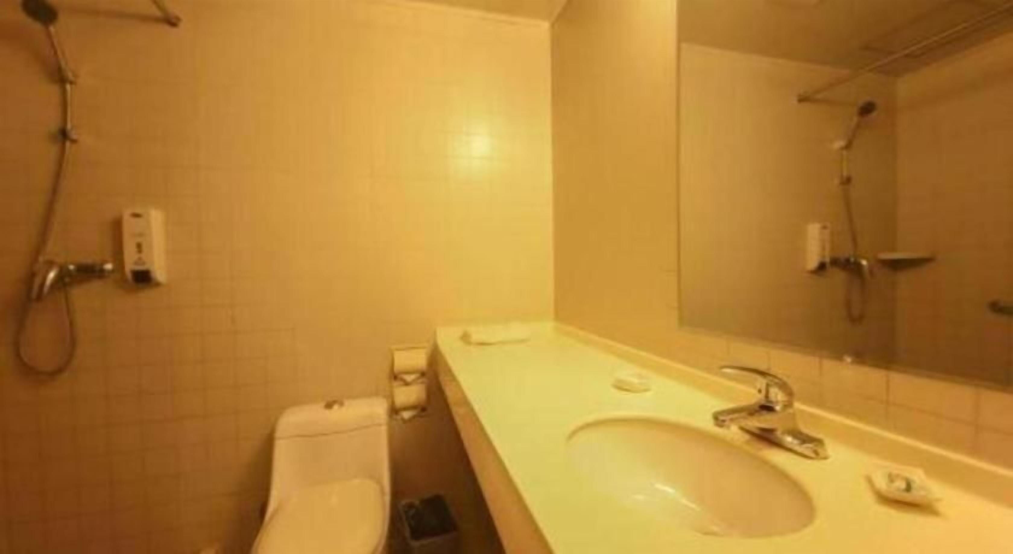 A bathroom with a toilet, sink, and shower.