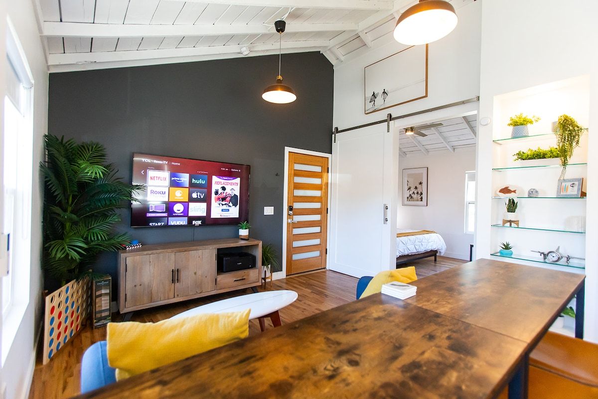 Open studio living and dining space with a smart TV and warm wood tones