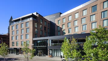 Ein modernes Hotel mit Ziegelaußenwand, großen Fenstern und einer markanten Eingangstür.