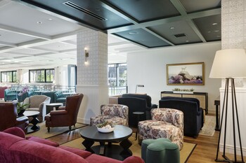 A spacious living room with a fireplace, a blue sofa, and a round coffee table. at Canopy By Hilton Boston Downtown