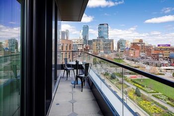 A spacious lobby with a staircase, modern furniture, and large windows offering city views. at Canopy By Hilton Boston Downtown