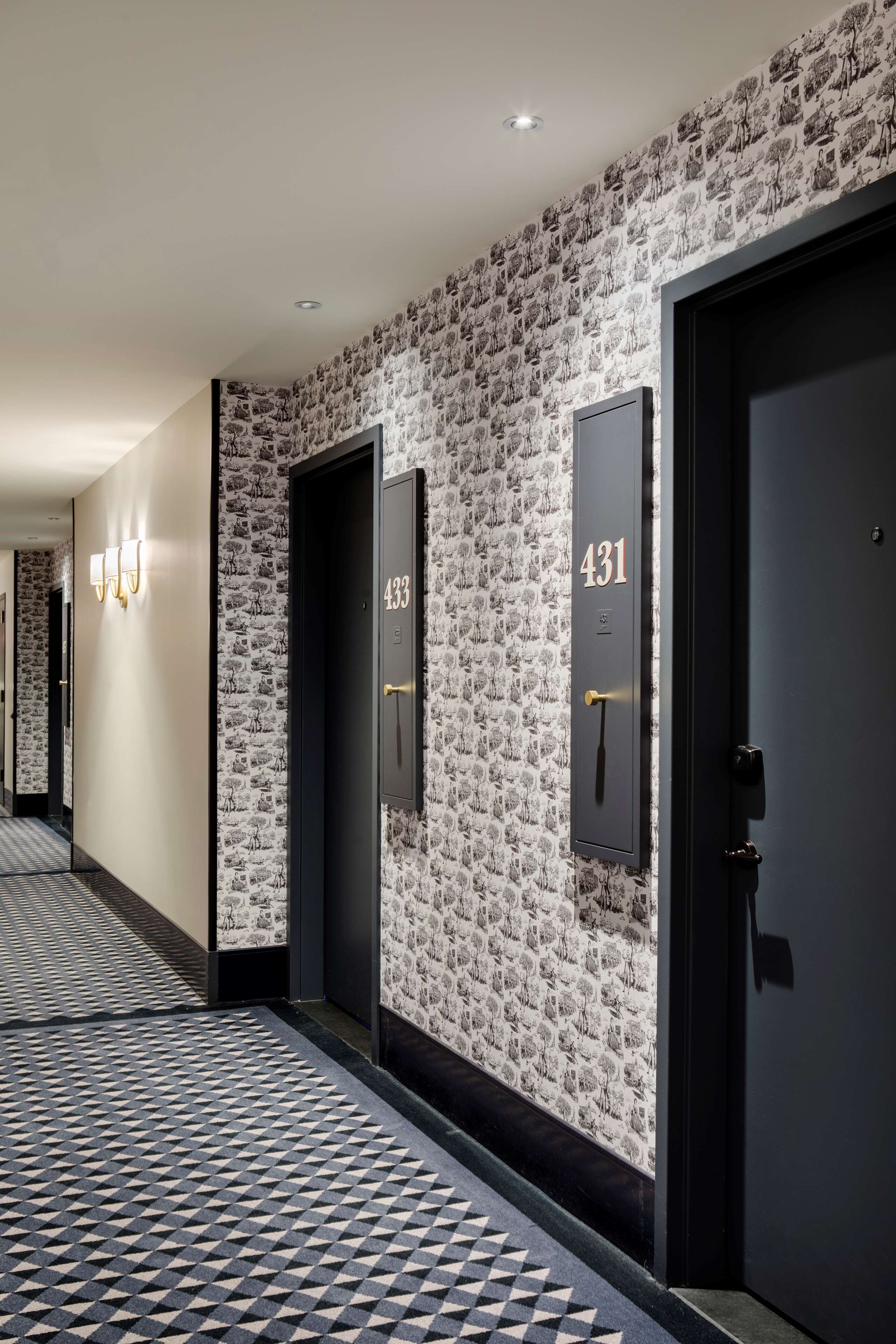 A hallway with a patterned wall, doors numbered 431 and 433, and a geometric patterned floor.