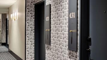 A hallway with a patterned wall, doors numbered 431 and 433, and a geometric patterned floor.