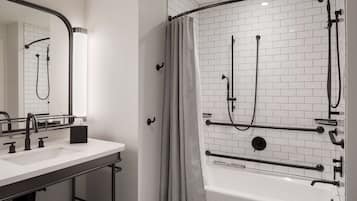A modern bathroom with a white-tiled shower, a bathtub, and a sink with a mirror.