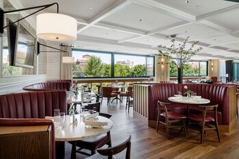 A modern hotel with multiple floors, large windows, and a well-lit entrance. at Canopy By Hilton Boston Downtown