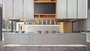 Une cuisine moderne dotée d’un îlot central, de meubles de rangement intégrés et d’une grande fenêtre donnant sur un paysage urbain.