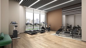 Une salle de sport moderne équipée de tapis de course, d’un rameur et de matériel d’haltérophilie.