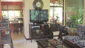 A living room with a television, a sofa, a coffee table, and a decorative elephant statue. - Casa Safari Maganda located in the middle of
paradise. (Tarcoles)