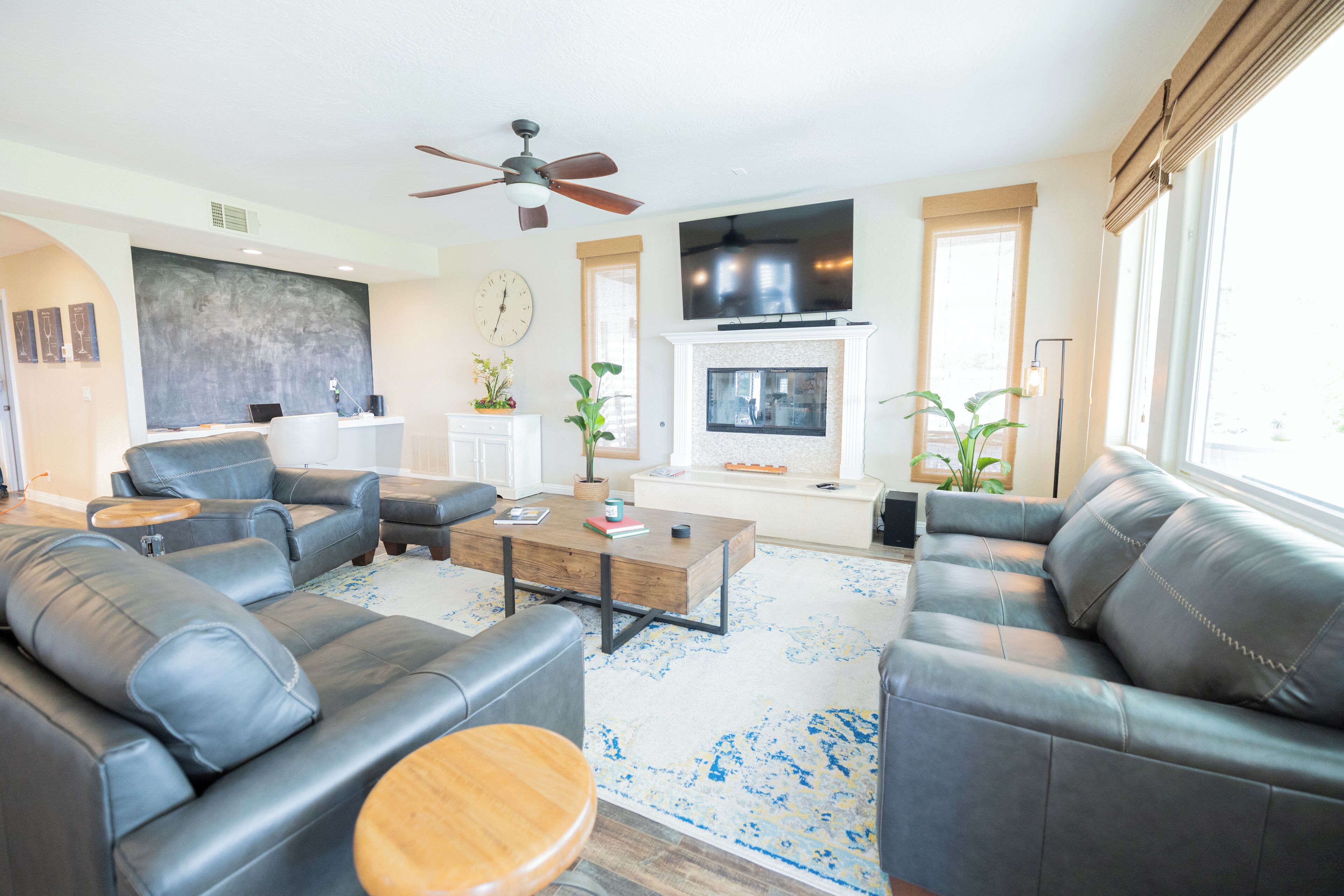 A modern living room with leather sofas, a coffee table, and a fireplace.