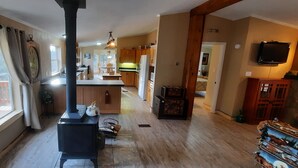 A spacious kitchen with a central island, wooden cabinets, and a built-in stove. - Forest cabin on 4 acres,  Newly renovated, Quiet and secluded. (Florissant)
