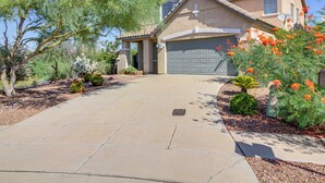 A residential house with a tiled roof, a garage, and a paved driveway. - Golfer's Paradise: Oro Valley Home w/ Pool! (Oro Valley)