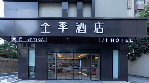 A hotel entrance with a modern design, featuring a glass facade and a sign indicating it is the 'Keting Hotel.'