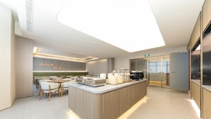 A modern kitchen with a central island, seating area, and a view of the city.