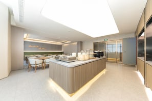 Une cuisine moderne dotée d’un îlot central, d’un coin repas et offrant une vue sur la ville.