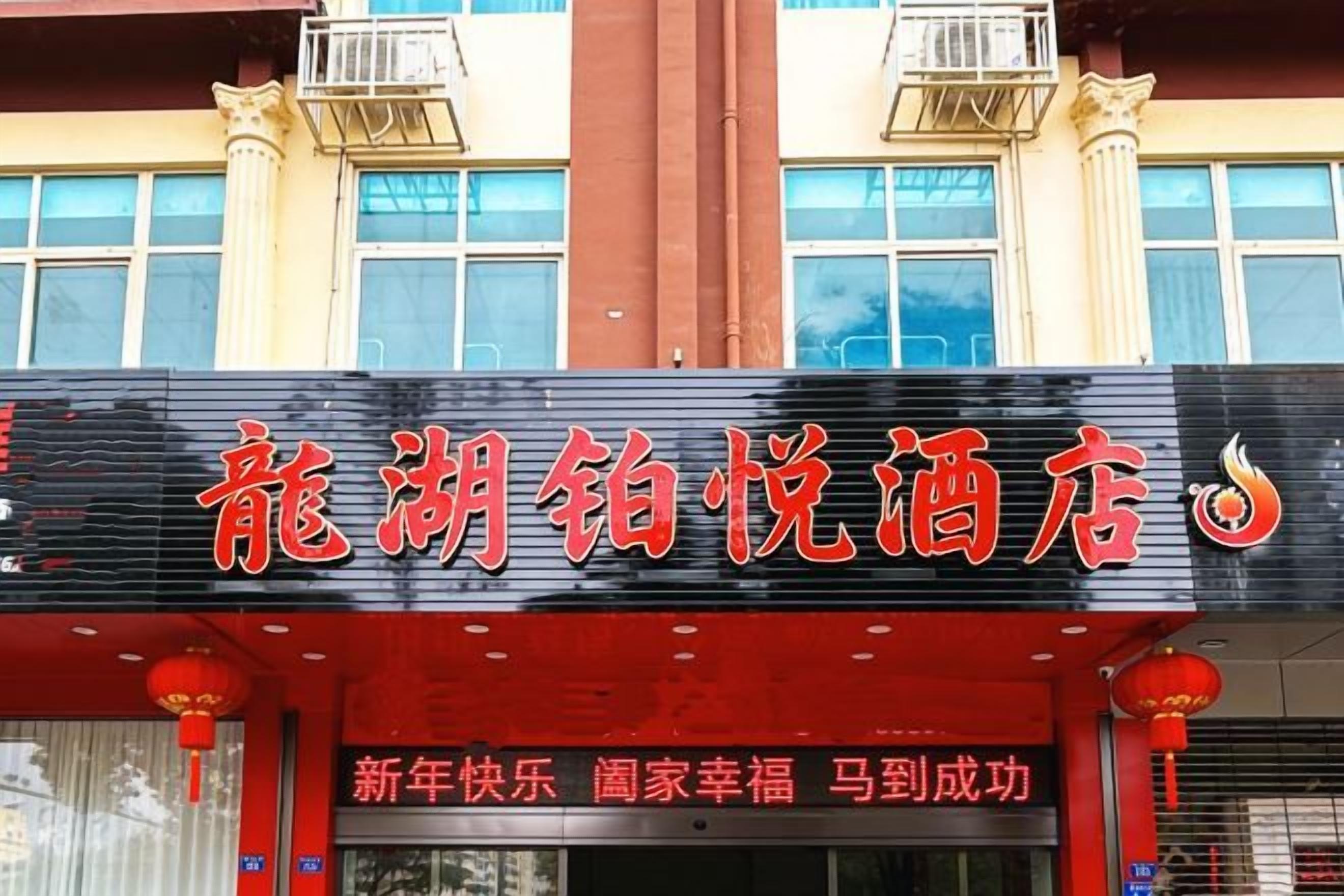 A hotel sign with Chinese characters and a red lantern.