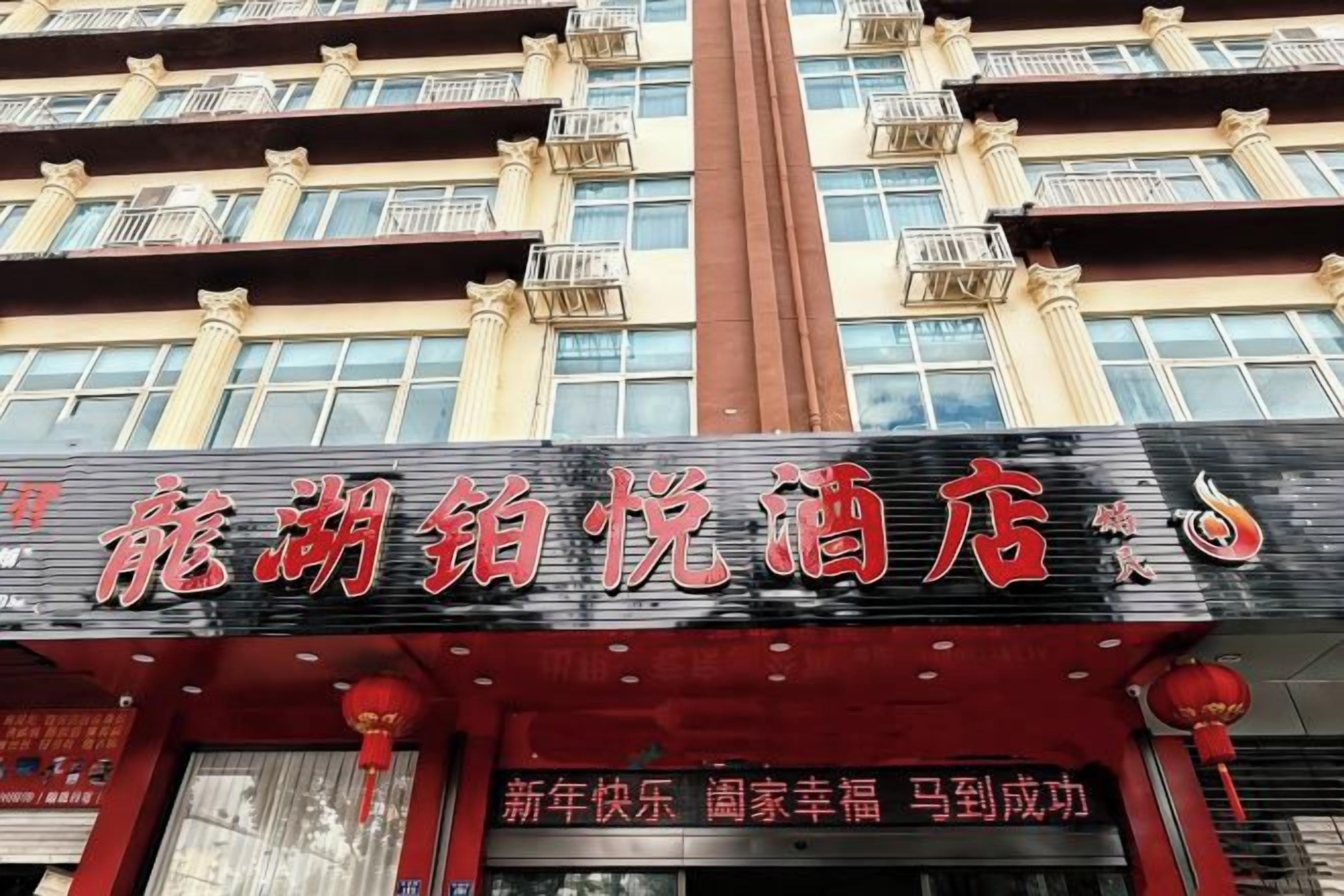 Un hotel con un cartello rosso e nero ben visibile.