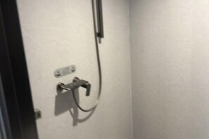 A bathroom with a shower, a wall-mounted electrical outlet, and a door. - Dehua Longhu Boyue Hotel (Dehua)