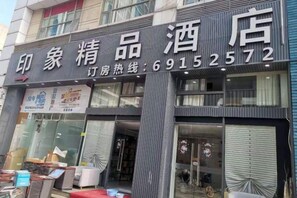 A hotel with a signboard displaying the name and contact number. - Impression Boutique Hotel (Shanghai Fengzhuang Metro Station Store) (Shanghai)