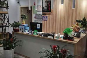 A reception desk with a computer, a digital display, and various informational signs. - Impression Boutique Hotel (Shanghai Fengzhuang Metro Station Store) (Shanghai)