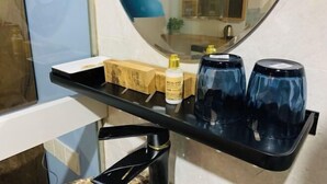 A bathroom with a black countertop, a mirror, and a blue lamp. - Impression Boutique Hotel (Shanghai Fengzhuang Metro Station Store) (Shanghai)