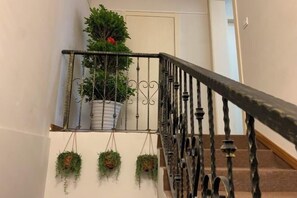 A staircase with a metal railing and potted plants. - Impression Boutique Hotel (Shanghai Fengzhuang Metro Station Store) (Shanghai)