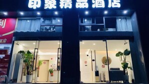 A hotel entrance with a sign in Chinese characters, glass doors, and potted plants inside. - Impression Boutique Hotel (Shanghai Fengzhuang Metro Station Store) (Shanghai)