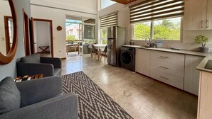 Eine moderne Küche mit Essbereich, großen Fenstern und einem Deckenventilator.
