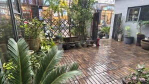 A wooden deck with potted plants and a lattice fence. - Nanchang 520 Youth Hotel (Mailu Campus Center store of University of Finance and Economics) (Nanchang)