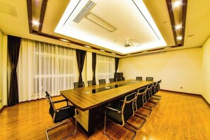 A conference room with a long table, chairs, and a ceiling light fixture. - Jin Du International Hotel (Langxi)