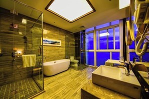 A modern bathroom with a glass-enclosed shower, a freestanding bathtub, and a large sink. - Jin Du International Hotel (Langxi)