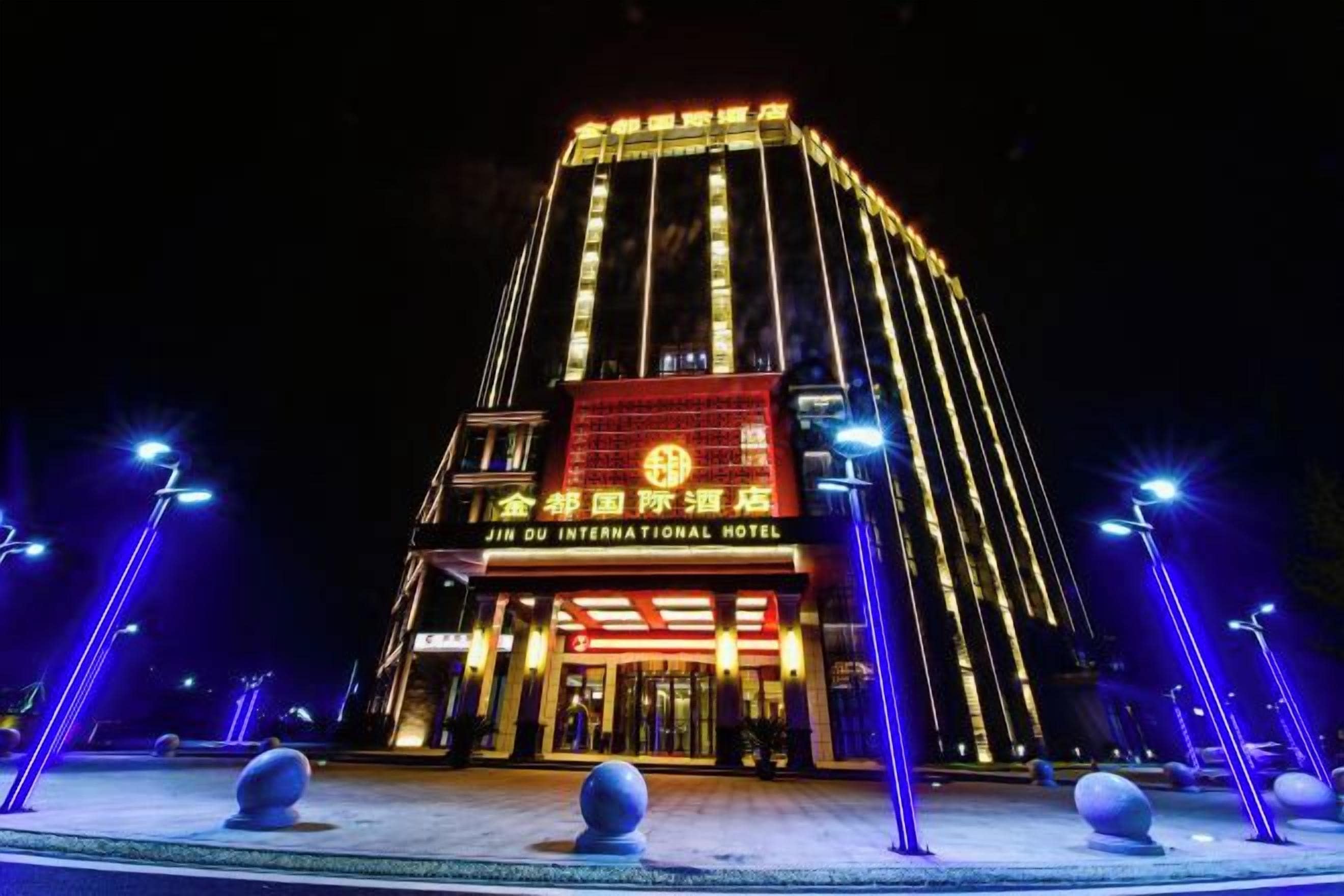 A tall hotel building with illuminated signage, a prominent entrance, and a symmetrical facade.