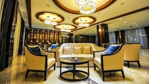 A lobby with a sofa set, a coffee table, and a chandelier. - Jin Du International Hotel (Langxi)