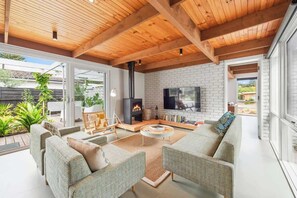 A modern living room with a fireplace, comfortable seating, and a TV.