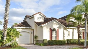 Ein eingeschossiges Haus mit weißer Fassade, einem braunen Ziegeldach und einer Garage.