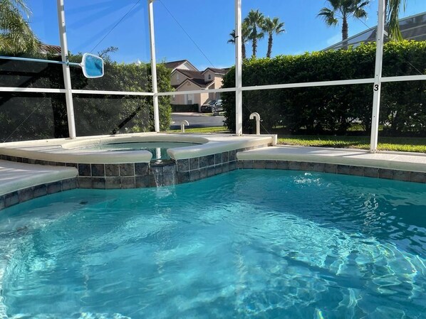 A swimming pool with a hot tub, surrounded by a fence and a view of residential houses. - Orlando Villa, Private Pool/Hot tub min to Disney (Davenport)