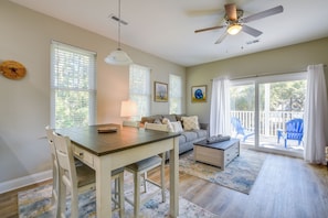 A spacious living room with a dining area, large windows, ceiling fan, and a view of the outdoors. - Murrells Inlet Home: Half-Mi to Marsh Walk! (Murrells Inlet)