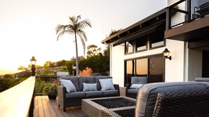 A deck with wicker furniture and a view of a modern house. - New! Breathtaking Patio Ocean Views, Private Riviera Retreat 30 Day Minimum (Santa Barbara)