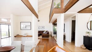 A spacious living area with a high ceiling, wooden beams, a glass dining table, and a cozy seating arrangement. - New! Breathtaking Patio Ocean Views, Private Riviera Retreat 30 Day Minimum (Santa Barbara)