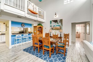 Relax in this stylish room with a balcony overlooking the interior, a dining table, and a comfortable sofa.