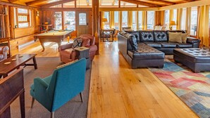 A spacious room with a pool table, leather sofas, and a billiards table. - New Denver Lodge – Relax, Unwind & Reconnect (New Denver)