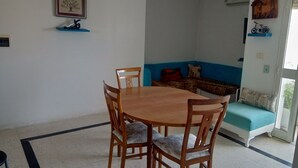 Un comedor con mesa y sillas de madera, un sofá azul y un cuadro en la pared.