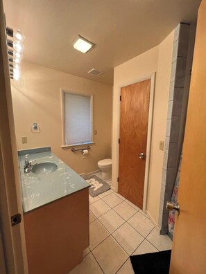 A bathroom with a sink, toilet, and a wooden door.