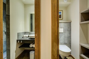 Ein modernes Badezimmer mit einem Holzwaschtisch, einem Waschbecken und einer Toilette.