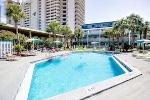 Relax by the pool surrounded by lush greenery and lounge under the shade of umbrellas.