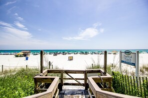 Stroll down to the beach from this condominium's staircase, where umbrellas and beach chairs await.