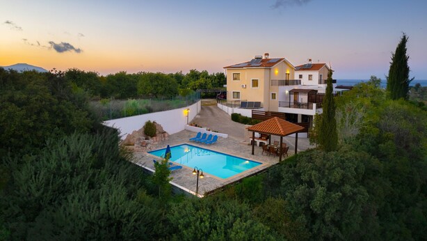 A two-story house with a swimming pool, surrounded by greenery and a clear sky. - Villa Ira Finiki: Private pool and gardens, A/C, Wi Fi, sea views (Latchi)