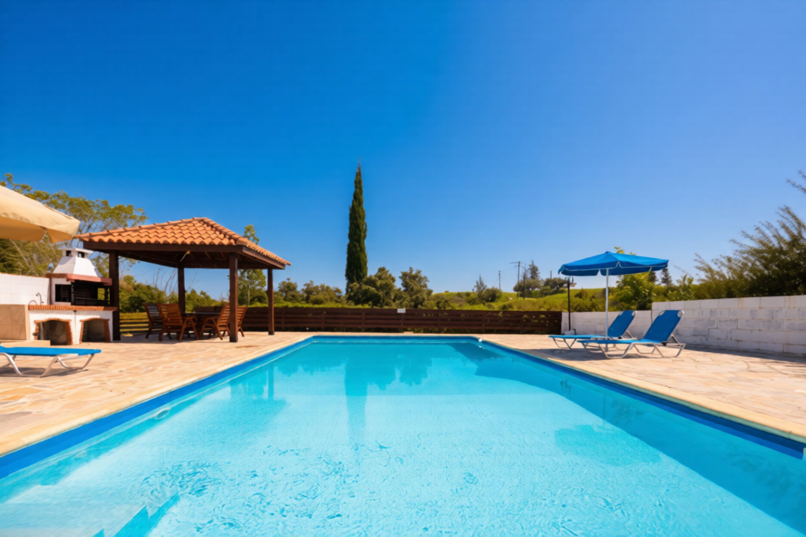 Ein Swimmingpool mit Liegestühlen und einer Grillanlage.